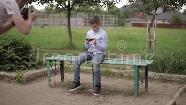 放学后坐在长凳上玩网络游戏的帅哥